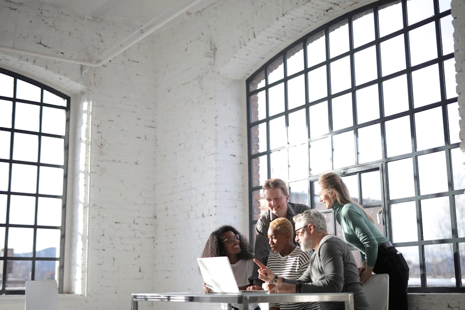 Team diversificato che collabora in un ufficio moderno e luminoso.